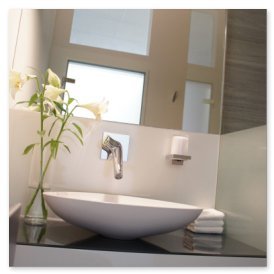 Das stilvolle Waschbecken aus weißem Keramik steht auf einer dunklen Oberfläche, umgeben von dekorativen Lilien und Handtüchern.