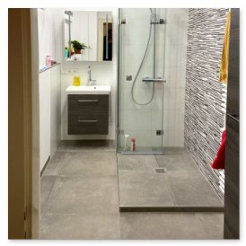 Ein modernes Badezimmer mit einer gläsernen Dusche und einem eleganten Waschbecken in neutralen Farbtönen.