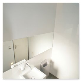 Der Blick auf ein elegantes Badezimmer, das durch einen großen Spiegel und eine saubere, helle Ästhetik besticht.
