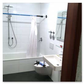 Das Badezimmer zeigt eine helle, saubere Umgebung mit einer Badewanne, einem Waschbecken und einem großen Spiegel an der Wand.