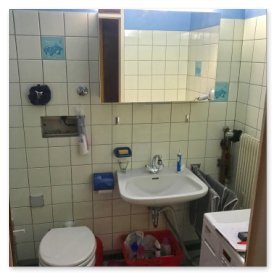 Das Badezimmer zeigt eine Toilette, ein Waschbecken und eine Handtuchhalterung, alles in einem kompakten Raum angeordnet.