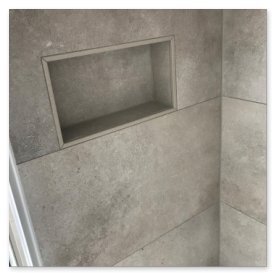 Die Wände der Dusche sind mit glatten, grauen Fliesen verkleidet, die eine elegante Atmosphäre schaffen.