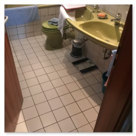 Das Badezimmer zeigt eine grüne Toilette und ein Waschbecken, beide mit Handtüchern und Pflegeprodukten dekoriert.
