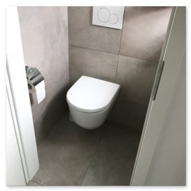 Der Blick auf eine stilvolle Toilette in einem kleinen, hellen Raum mit neutralen Farben und einem eleganten Waschbecken.
