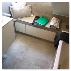 Der Raum zeigt eine stilvolle Badewanne, einen hellen Boden und eine Ablage mit Handtüchern und Notizmaterialien.