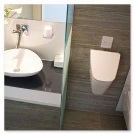 Das Bild zeigt ein stilvolles Waschbecken mit einem modernen Wasserhahn und einem schlichten, hängenden WC in einem Badezimmer.